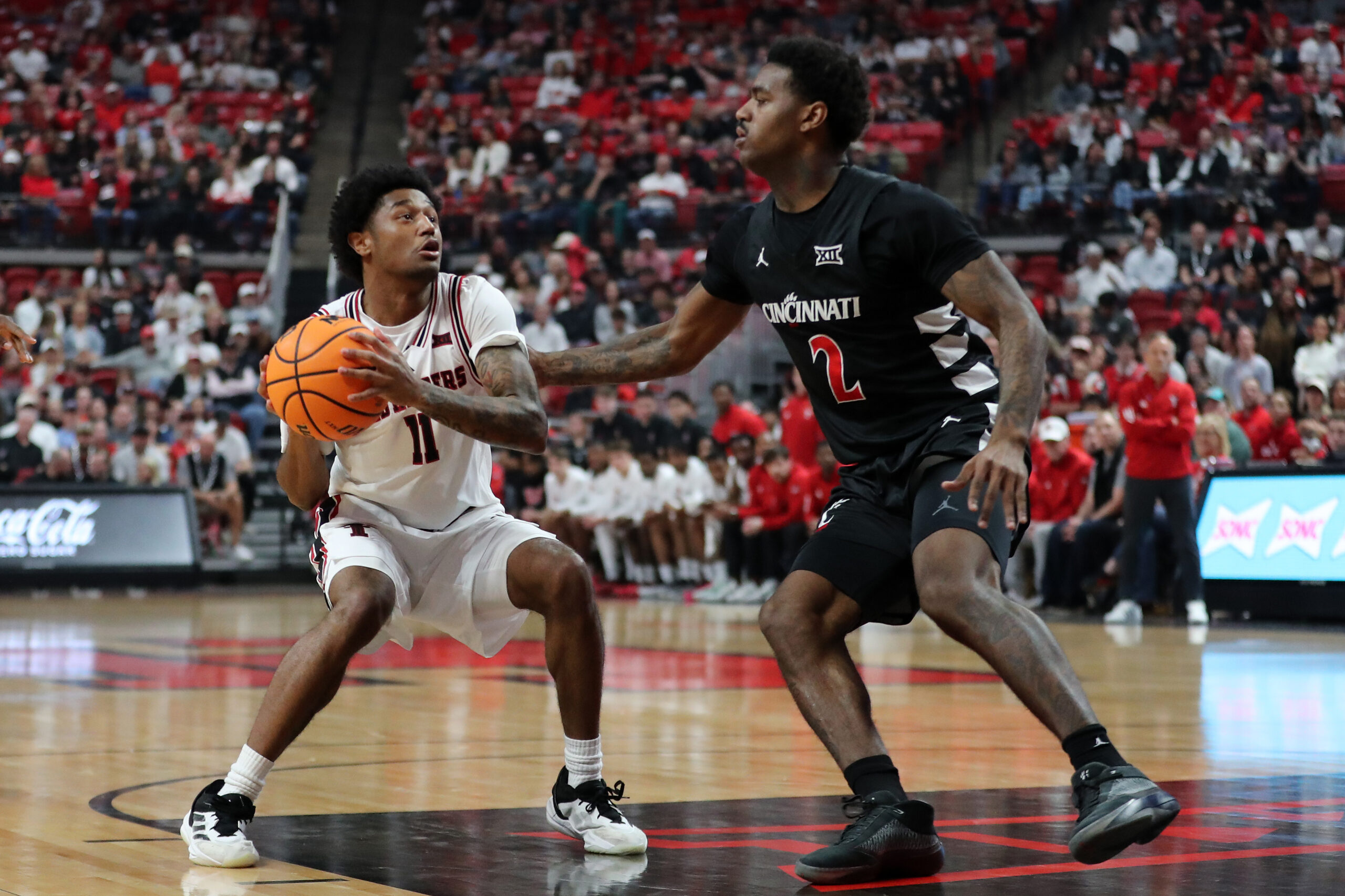 Feb 24, 2026; Lubbock, Texas, USA; Texas Tech Red Raiders guard Jaylen Petty (11) drives against Cincinnati Bearcats guard Jizzle James (2) in the first half at United Supermarkets Arena. Mandatory Credit: Michael C. Johnson-Imagn Images