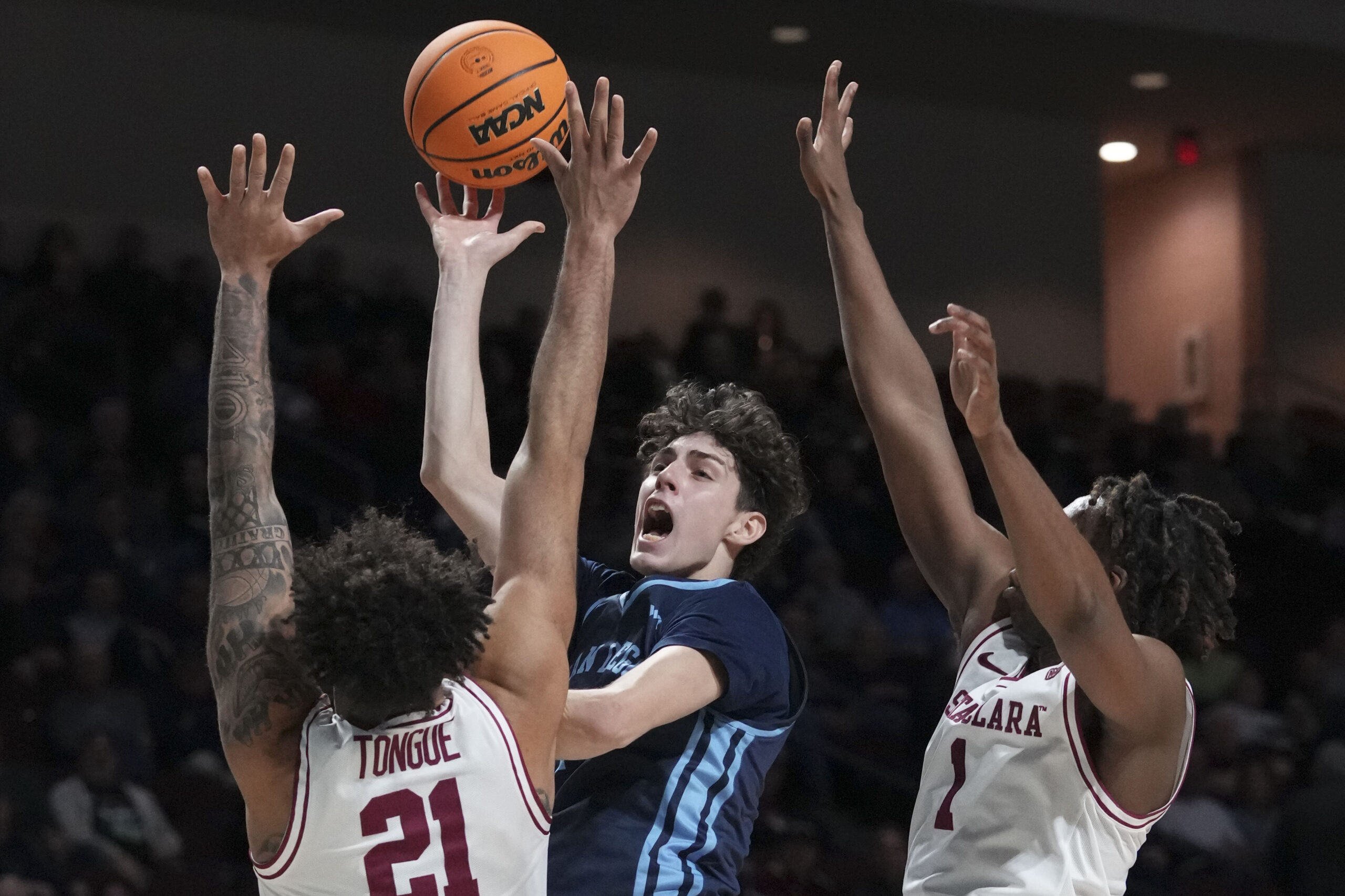March 9, 2024; Las Vegas, NV, USA; San Diego Toreros guard Dragos Lungu (7) shoots the basketball against Santa Clara Broncos forward Camaron Tongue (21) and guard Tyeree Bryan (1) during the first half in the quarterfinals of the WCC Basketball Championship at Orleans Arena. Mandatory Credit: Kyle Terada-Imagn Images