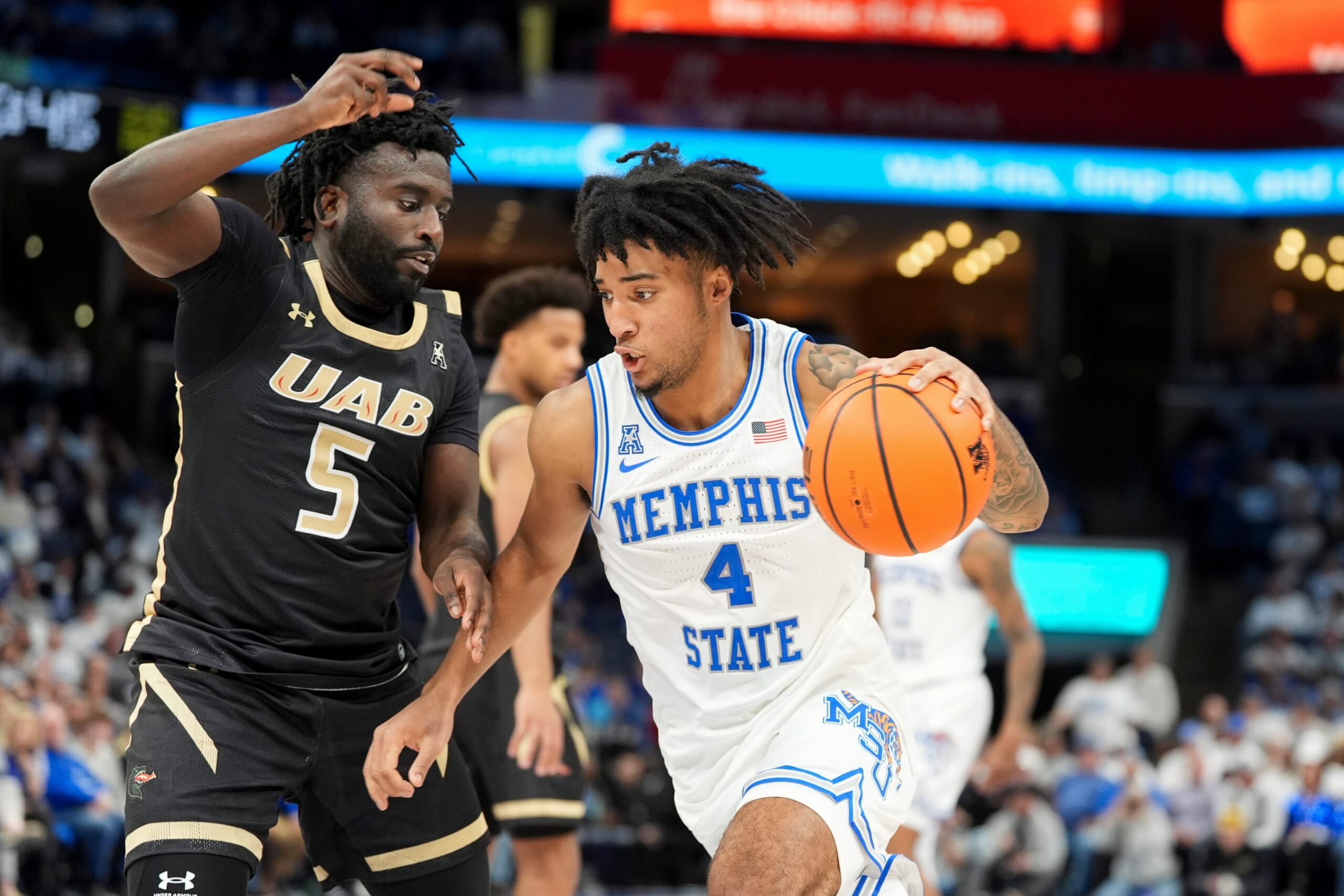 Memphis' PJ Haggerty (4) drives to the basket as UAB’s Tyren Moore (5) guards him during the game between University of Memphis and University of Alabama at Birmingham at FedExForum on Sunday, January 26, 2025, in Memphis, Tenn.