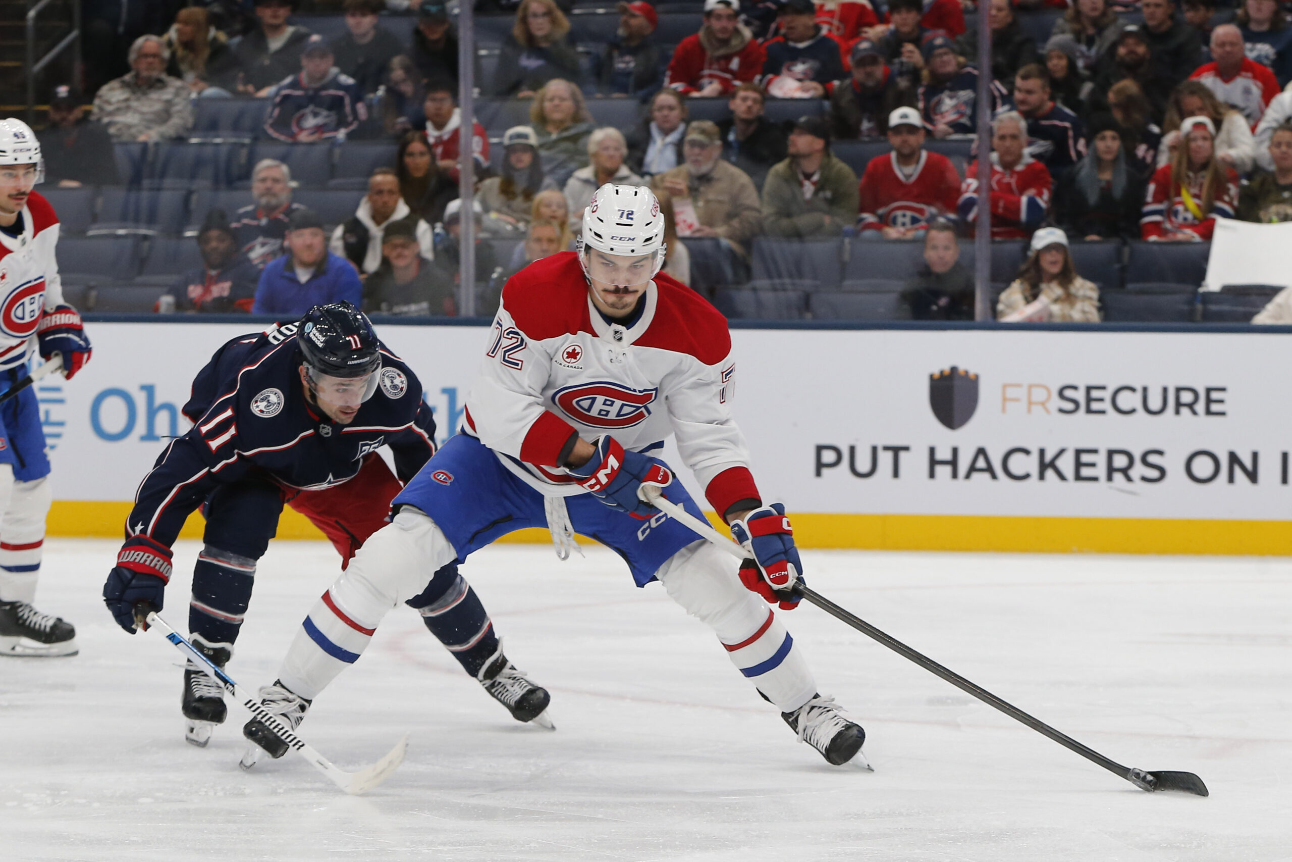 Nov 17, 2025; Columbus, Ohio, USA; Montreal Canadiens defenseman Arber Xhekaj (72) controls the puck as Columbus Blue Jackets left wing Miles Wood (11) trails the play during the second period at Nationwide Arena. Mandatory Credit: Russell LaBounty-Imagn Images