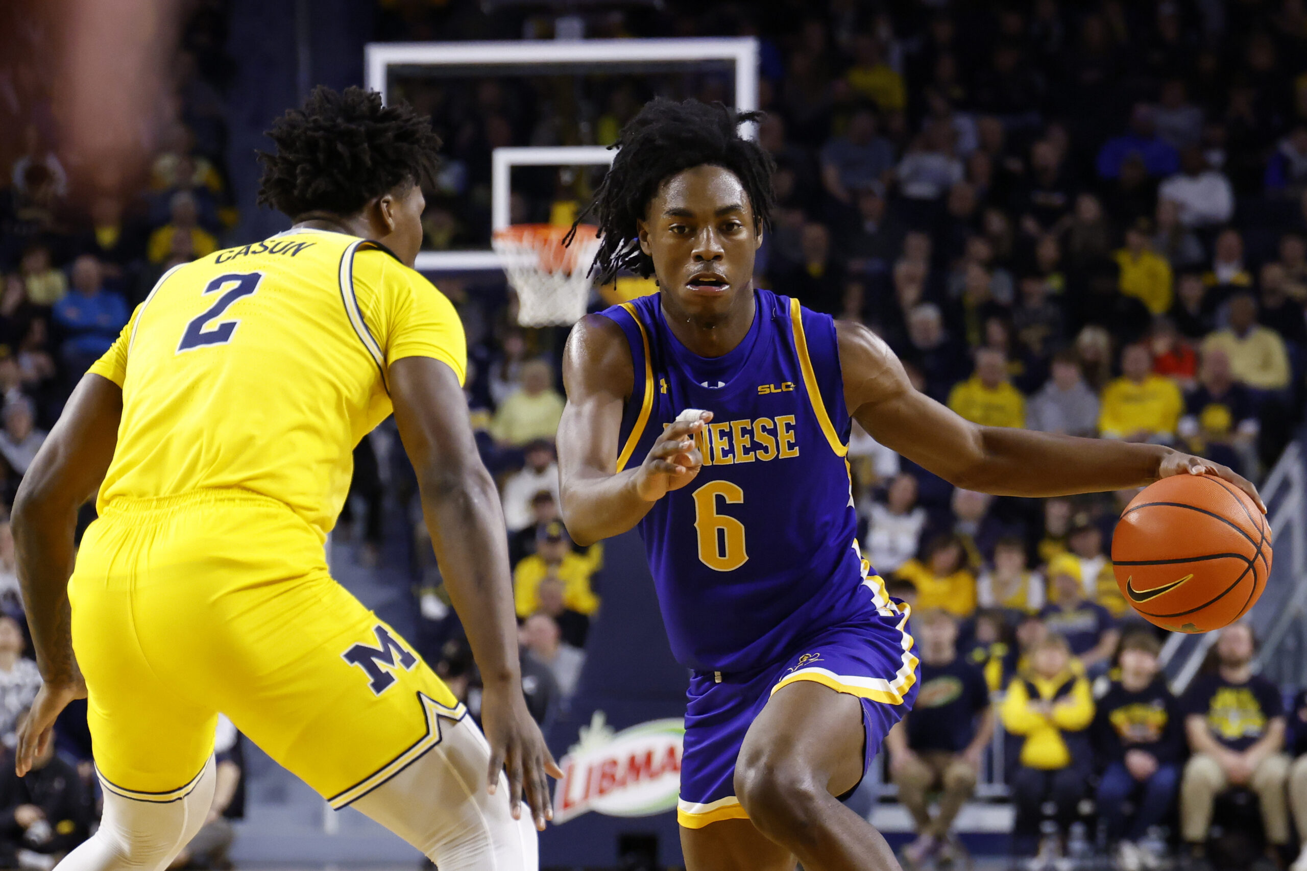 Dec 29, 2025; Ann Arbor, Michigan, USA;  McNeese Cowboys guard Larry Johnson (6) dribbles defended by Michigan Wolverines guard L.J. Cason (2) in the second half at Crisler Center. Mandatory Credit: Rick Osentoski-Imagn Images