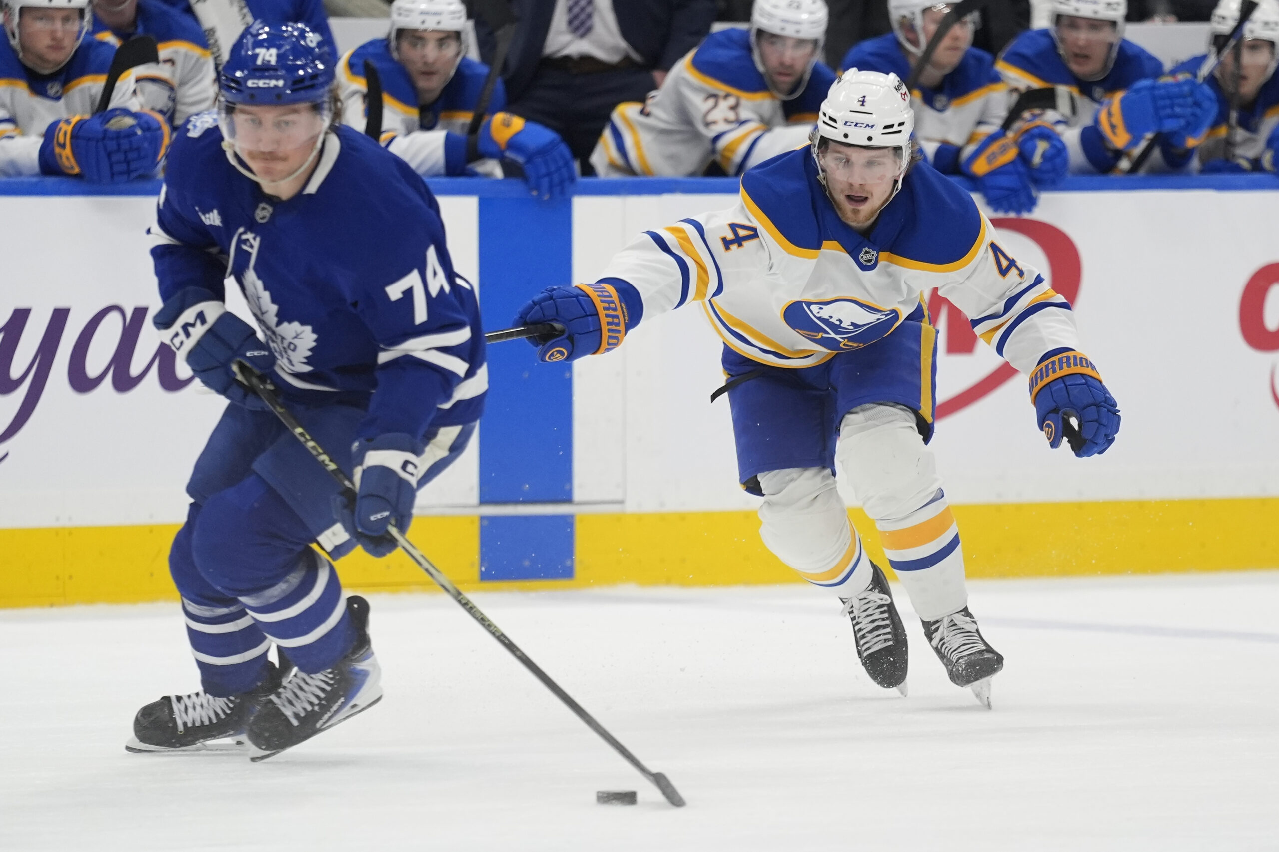 Jan 27, 2026; Toronto, Ontario, CAN; Buffalo Sabres defenseman Bowen Byram (4) tries to slow down Toronto Maple Leafs forward Bobby McMann (74) during the third period at Scotiabank Arena. Mandatory Credit: John E. Sokolowski-Imagn Images