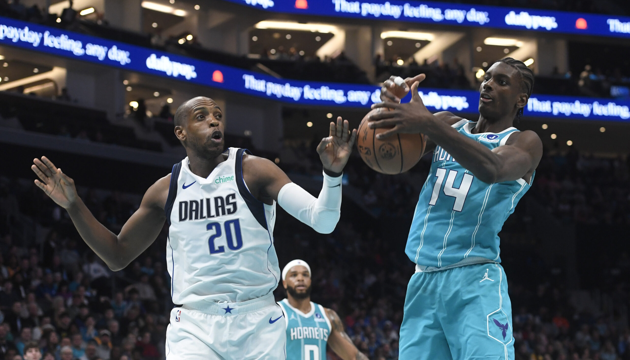 Mar 3, 2026; Charlotte, North Carolina, USA;  Dallas Mavericks forward Khris Middleton (20) and Charlotte Hornets forward center Moussa Diabate (14) fight for a rebound during the first half at the Spectrum Center. Mandatory Credit: Sam Sharpe-Imagn Images
