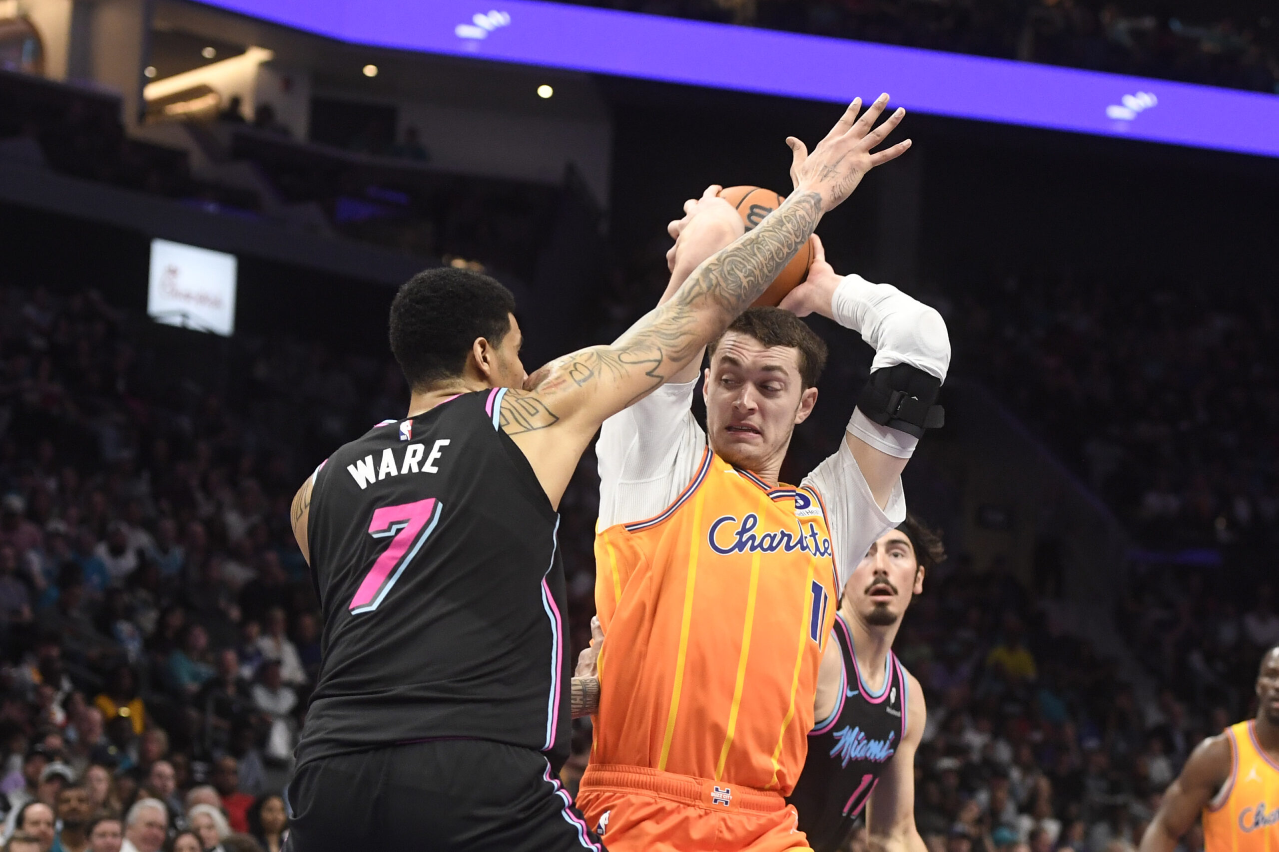 Mar 6, 2026; Charlotte, North Carolina, USA;  Charlotte Hornets center Ryan Kalkbrenner (11) looks to pass as he is defended by Miami Heat center Kel’el Ware (7) during the second half at the Spectrum Center. Mandatory Credit: Sam Sharpe-Imagn Images