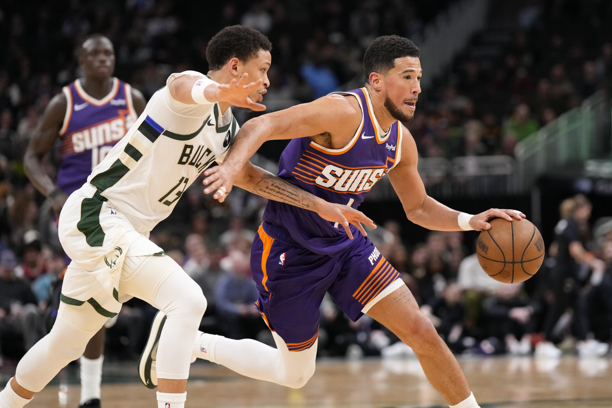 Mar 10, 2026; Milwaukee, Wisconsin, USA;  Phoenix Suns guard Devin Booker (1) drives towards the basket against Milwaukee Bucks guard Ryan Rollins (13) during the third quarter at Fiserv Forum. Mandatory Credit: Jeff Hanisch-Imagn Images