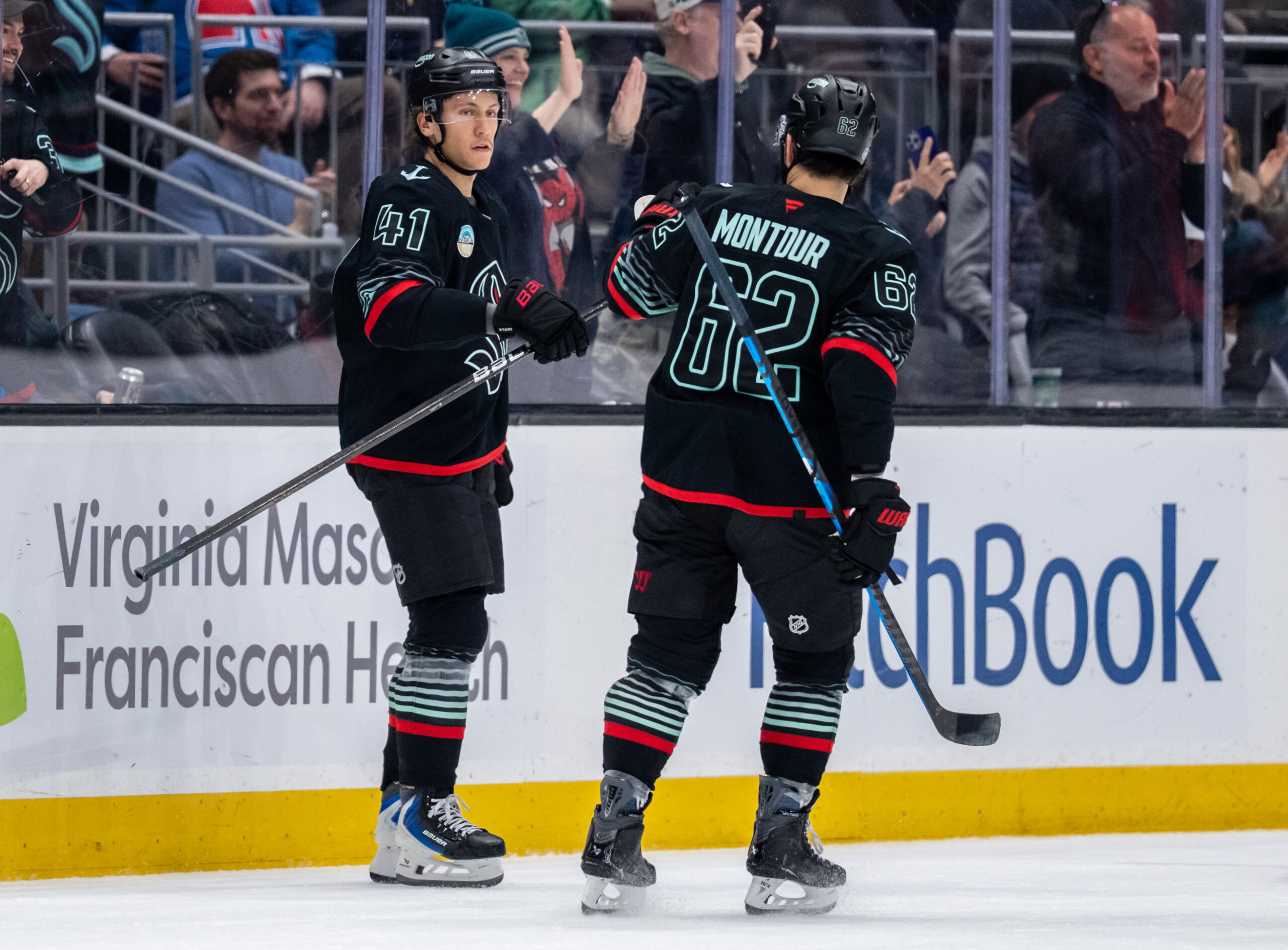 Mar 12, 2026; Seattle, Washington, USA; Seattle Kraken defenseman Ryker Evans (41) is congratulated by Seattle Kraken defenseman Brandon Montour (62) after scoring a goal during the second period against the Colorado Avalanche at Climate Pledge Arena. Mandatory Credit: Stephen Brashear-Imagn Images