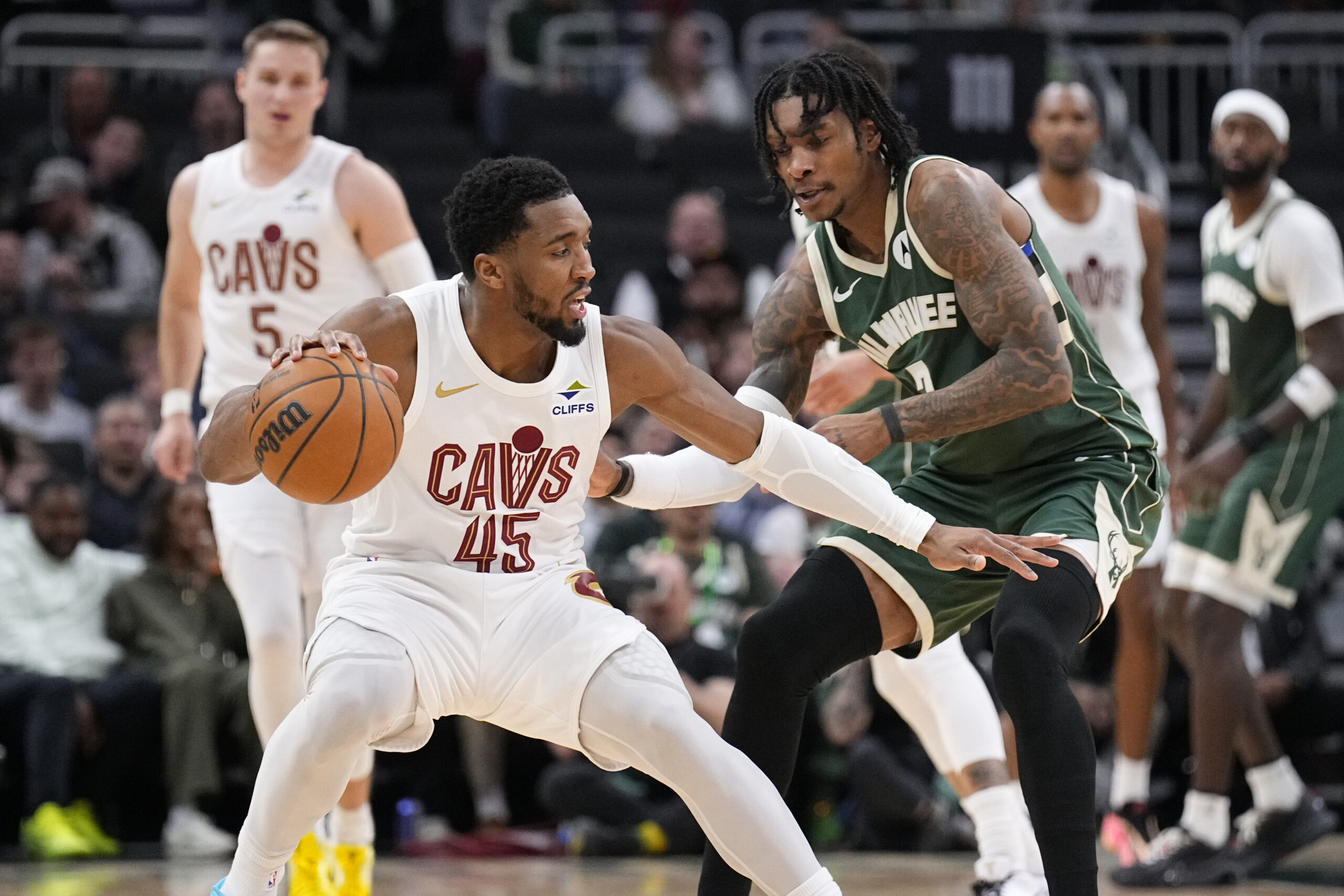 Mar 17, 2026; Milwaukee, Wisconsin, USA; Cleveland Cavaliers guard Donovan Mitchell (45) drives against Milwaukee Bucks guard/forward Kevin Porter Jr. (7) in the second half at Fiserv Forum. Mandatory Credit: Michael McLoone-Imagn Images