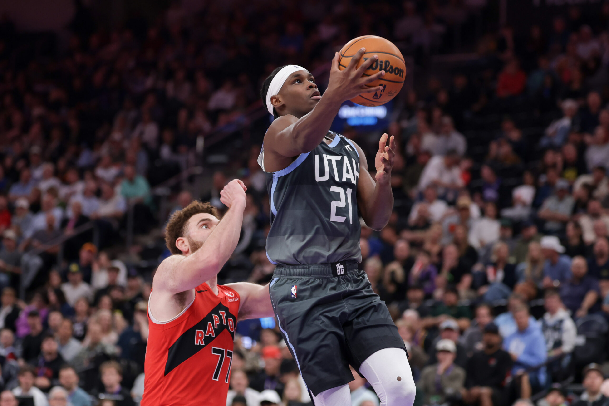 Mar 23, 2026; Salt Lake City, Utah, USA;  Utah Jazz guard Bez Mbeng (21) gets past Toronto Raptors forward Jamison Battle (77) and to the basket during the second quarter at Delta Center. Mandatory Credit: Chris Nicoll-Imagn Images