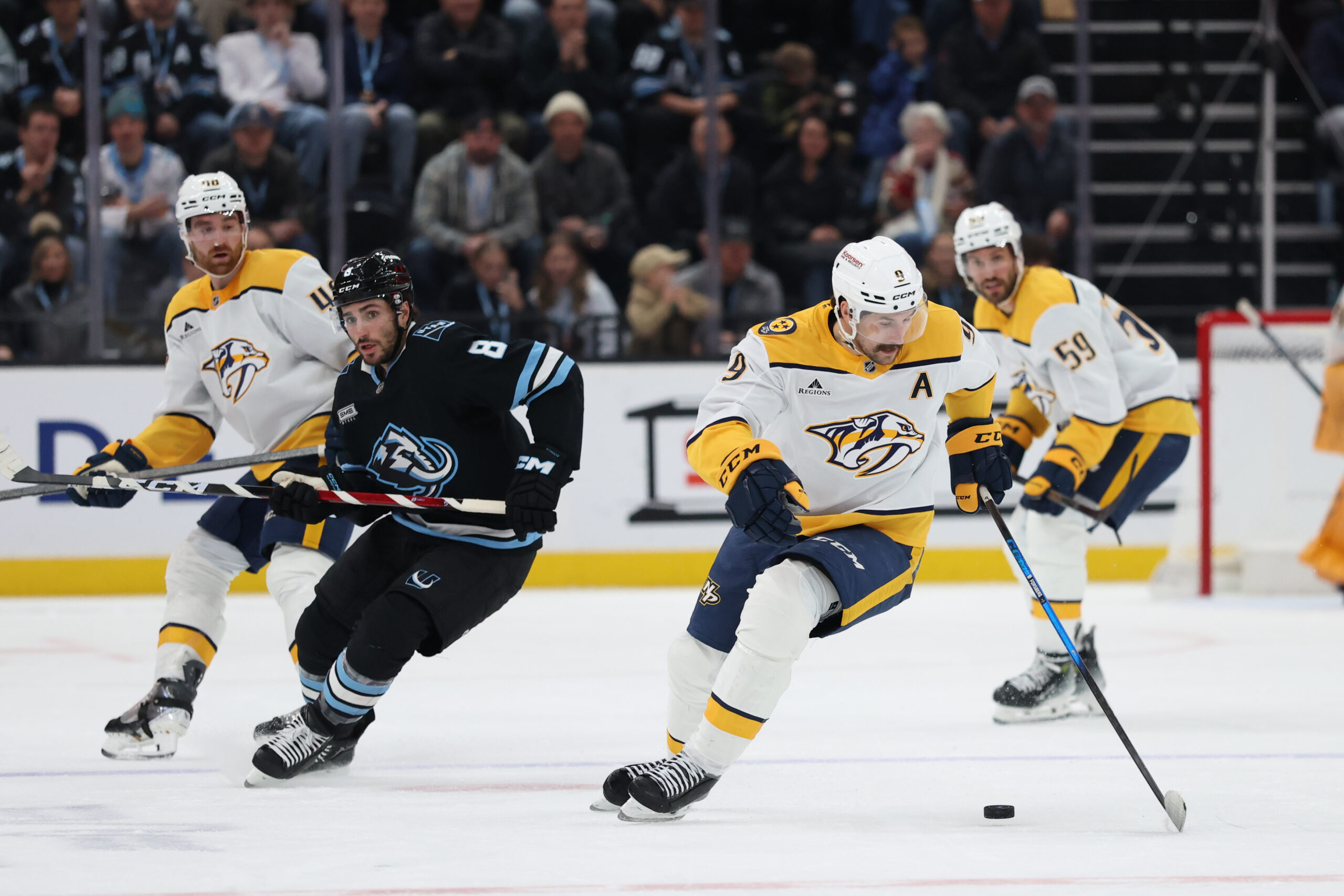 Dec 29, 2025; Salt Lake City, Utah, USA; Nashville Predators left wing Filip Forsberg (9) moves the puck as Utah Mammoth center Nick Schmaltz (8) defends during the second period at Delta Center. Mandatory Credit: Rob Gray-Imagn Images