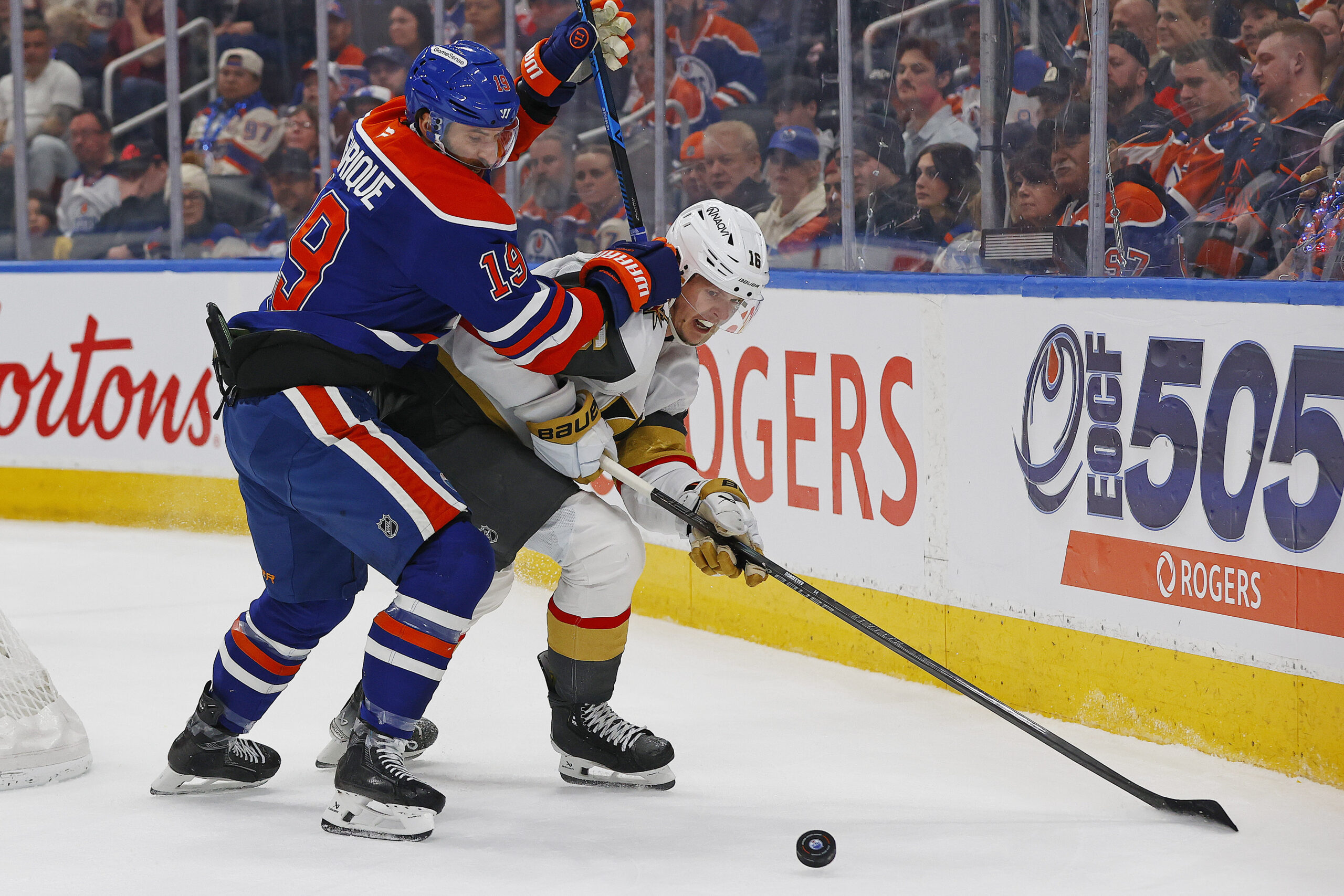 Apr 4, 2026; Edmonton, Alberta, CAN; Edmonton Oilers forward Adam Henrique (19) and Vegas Golden Knights forward Pavel Dorofeyev (16) battle along the boards for a loose puck during the second period at Rogers Place. Mandatory Credit: Perry Nelson-Imagn Images