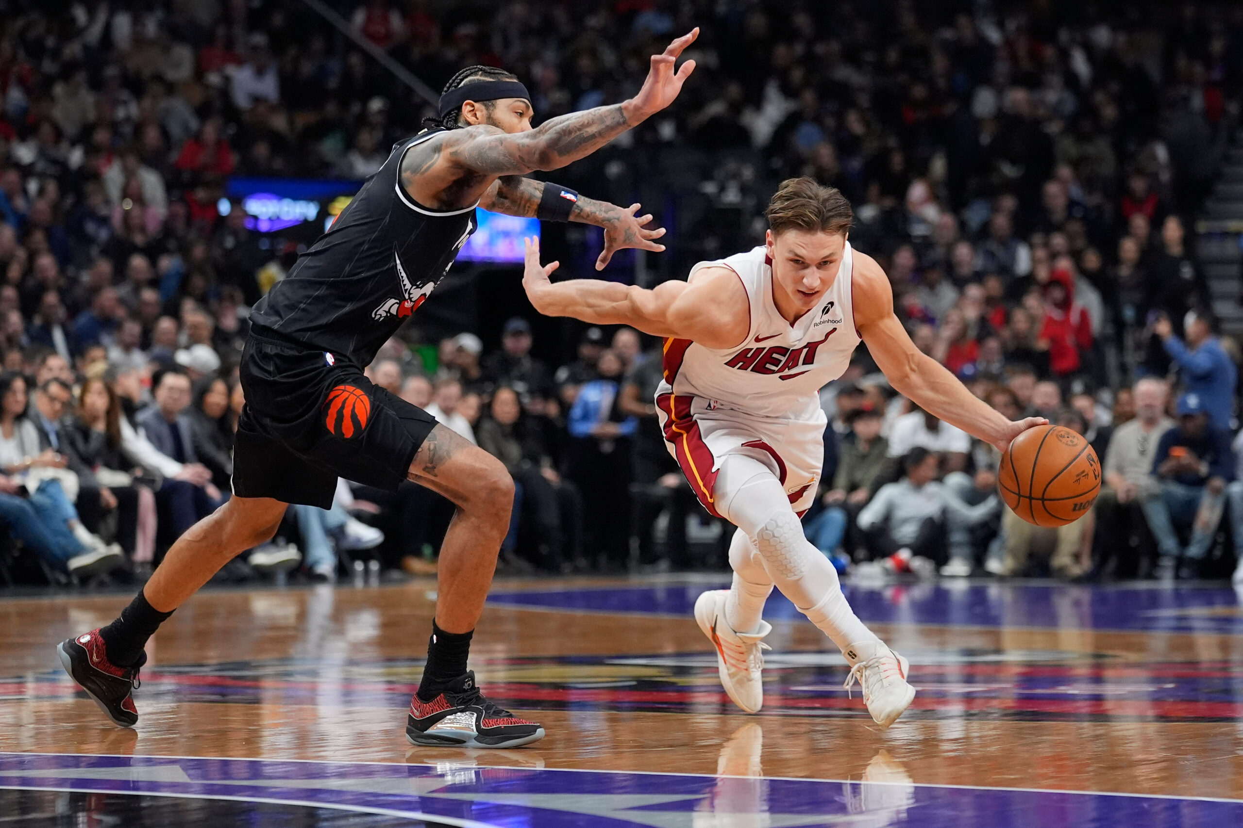 Apr 9, 2026; Toronto, Ontario, CAN; Miami Heat forward Pelle Larsson (9) drives to the basket against Toronto Raptors forward Brandon Ingram (3) during the first half at Scotiabank Arena. Mandatory Credit: John E. Sokolowski-Imagn Images