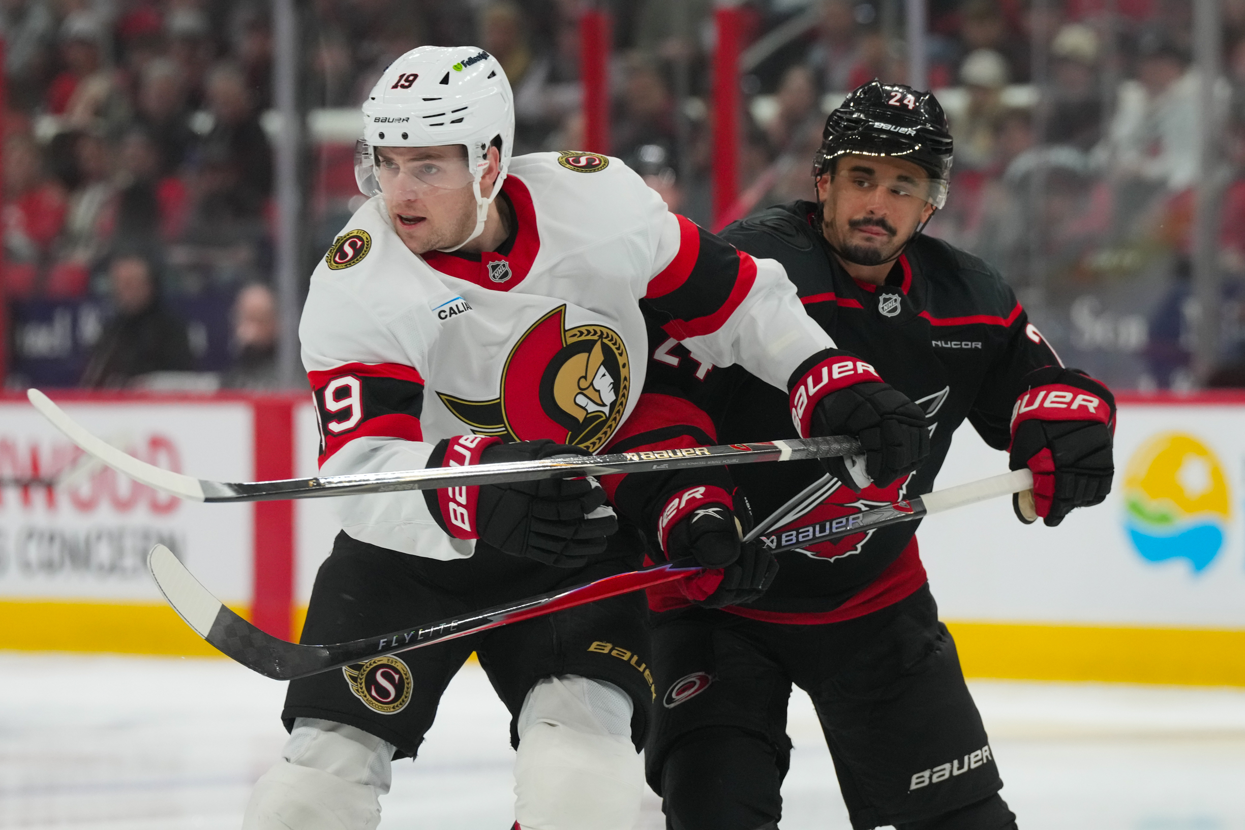 Apr 20, 2026; Raleigh, North Carolina, USA; Carolina Hurricanes center Seth Jarvis (24) and Ottawa Senators right wing Drake Batherson (19) battle in the first overtime period in game two of the first round of the 2026 Stanley Cup Playoffs at Lenovo Center. Mandatory Credit: James Guillory-Imagn Images