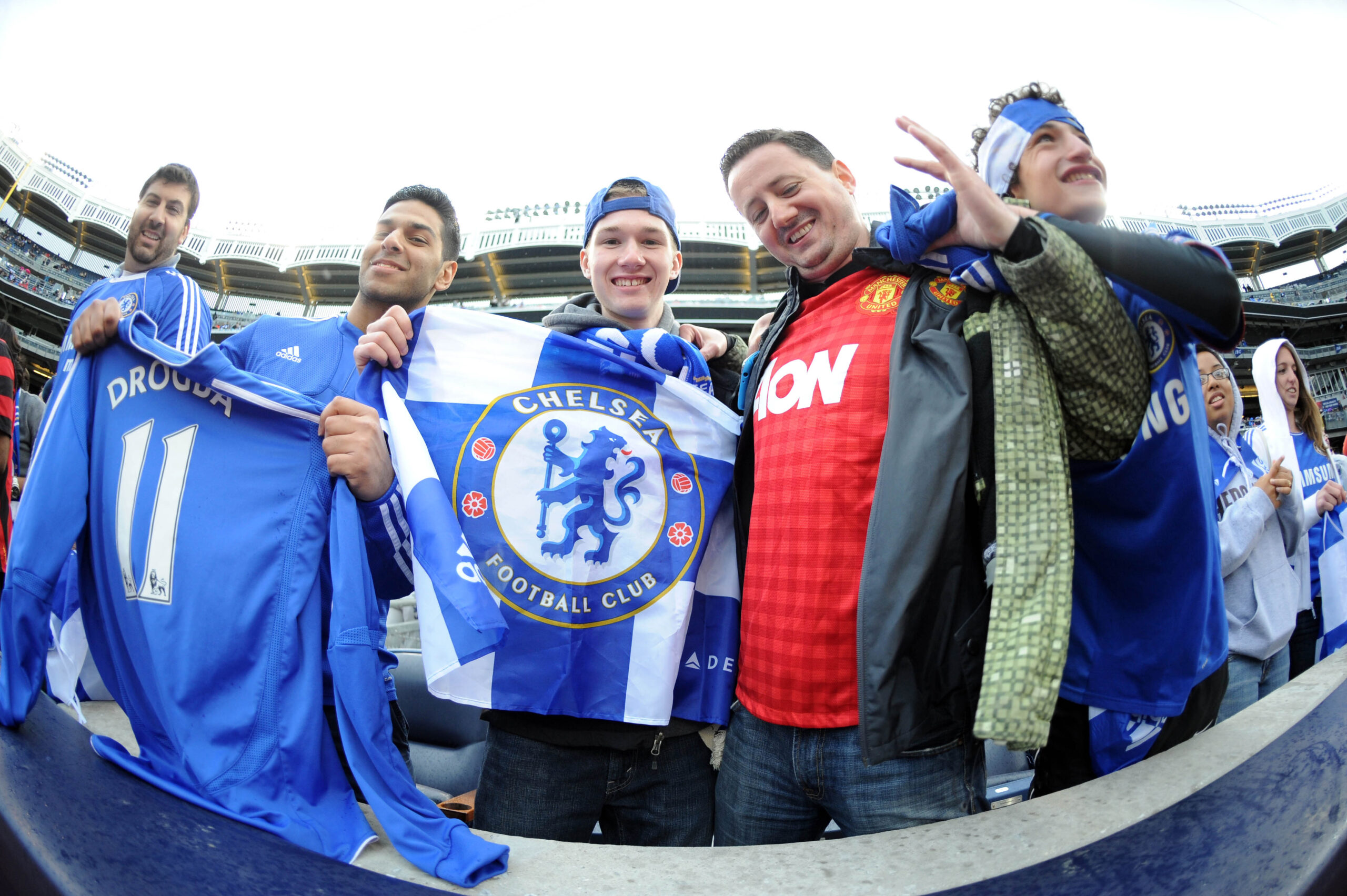 May 25, 2013; Bronx, NY, USA; A Manchester United fan (red) cheers with Chelsea fans before the first half against Manchester City at Yankee Stadium. Manchester City won 5-3. Mandatory Credit: Joe Camporeale-Imagn Images