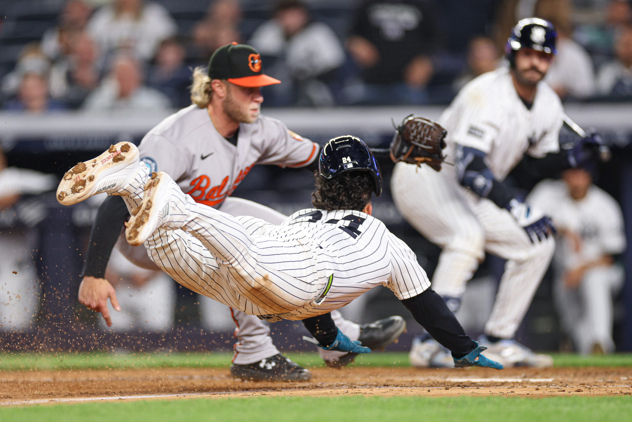 May 4, 2026; Bronx, New York, USA; New York Yankees left fielder Jasson Dominguez (24) scores a run won a wild pitch before being tagged by Baltimore Orioles pitcher Shane Baz (34) during the sixth inning at Yankee Stadium. Mandatory Credit: Vincent Carchietta-Imagn Images
