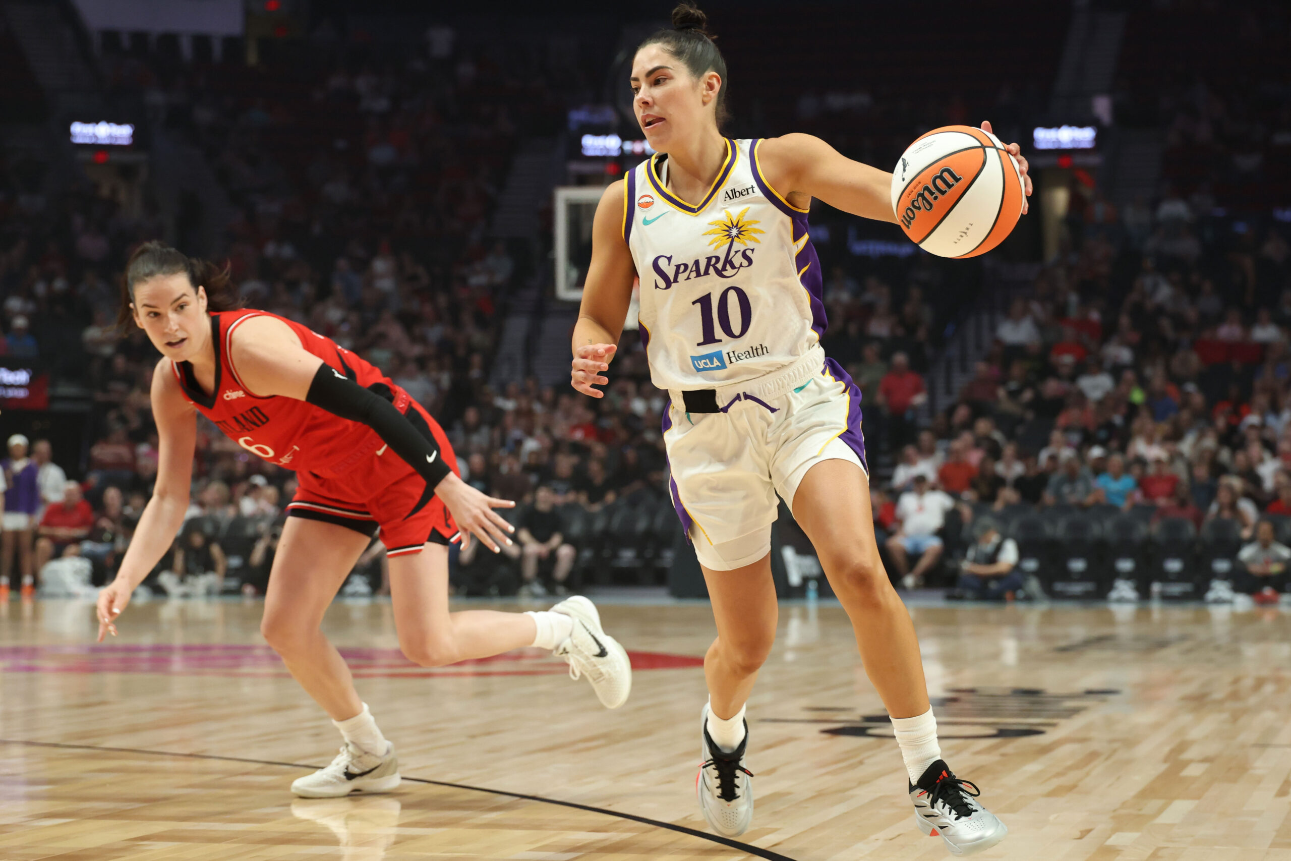 May 3, 2026; Portland, OR, USA;  Los Angeles Sparks guard Kelsey Plum (10) gets control of the ball against Portland Fire forward Bridget Carleton (6) at Moda Center. Mandatory Credit: Jaime Valdez-Imagn Images