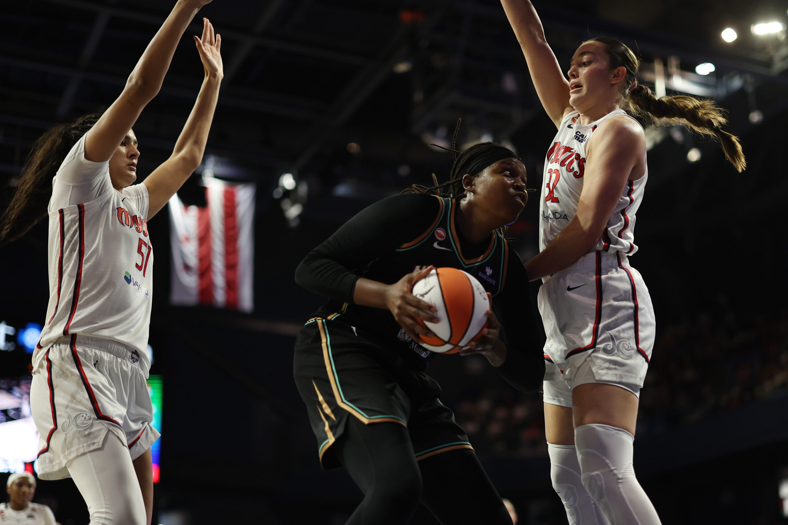 May 10, 2026; Washington, District of Columbia, USA; New York Liberty center Jonquel Jones (35) drives to the basket as Washington Mystics center Lauren Betts (51) and Mystics forward Angela Dugalic (32) defend in the second half at CareFirst Arena. Mandatory Credit: Geoff Burke-Imagn Images