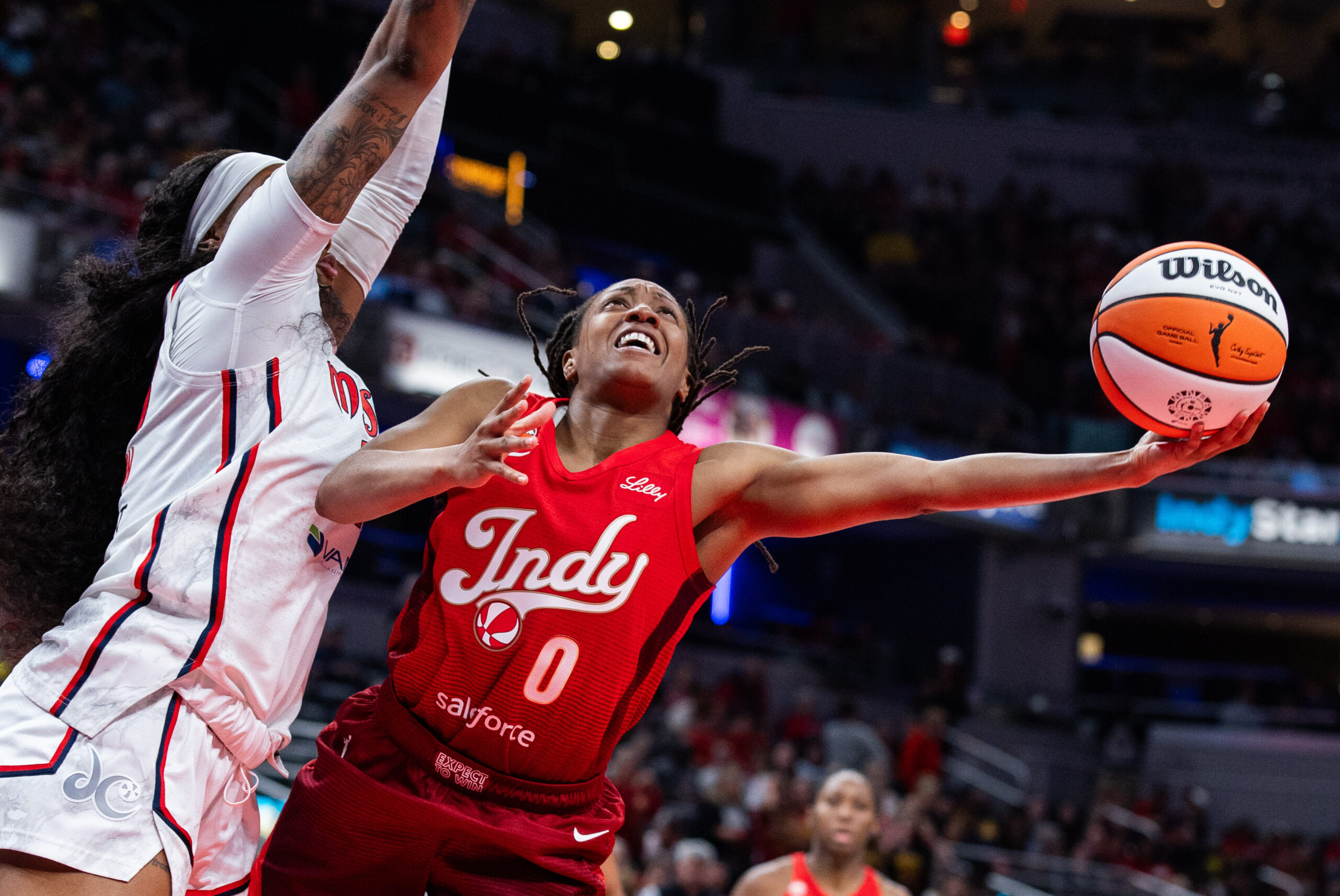 May 15, 2026; Indianapolis, Indiana, USA; Indiana Fever guard Kelsey Mitchell (0) shoots the ball while Washington Mystics forward Kiki Iriafen (44) defends in the second half at Gainbridge Fieldhouse. Mandatory Credit: Trevor Ruszkowski-Imagn Images