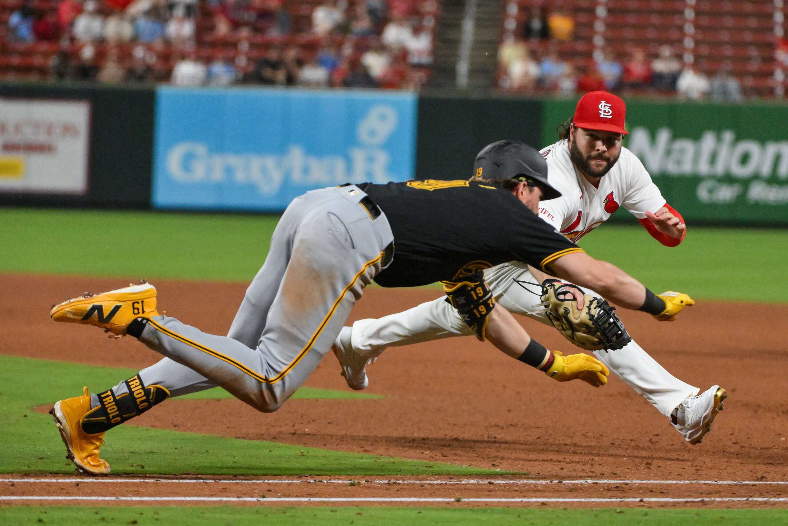 May 19, 2026; St. Louis, Missouri, USA; St. Louis Cardinals first baseman Alec Burleson (41) dives and tags out Pittsburgh Pirates shortstop Jared Triolo (19) during the eighth inning at Busch Stadium. Mandatory Credit: Jeff Curry-Imagn Images