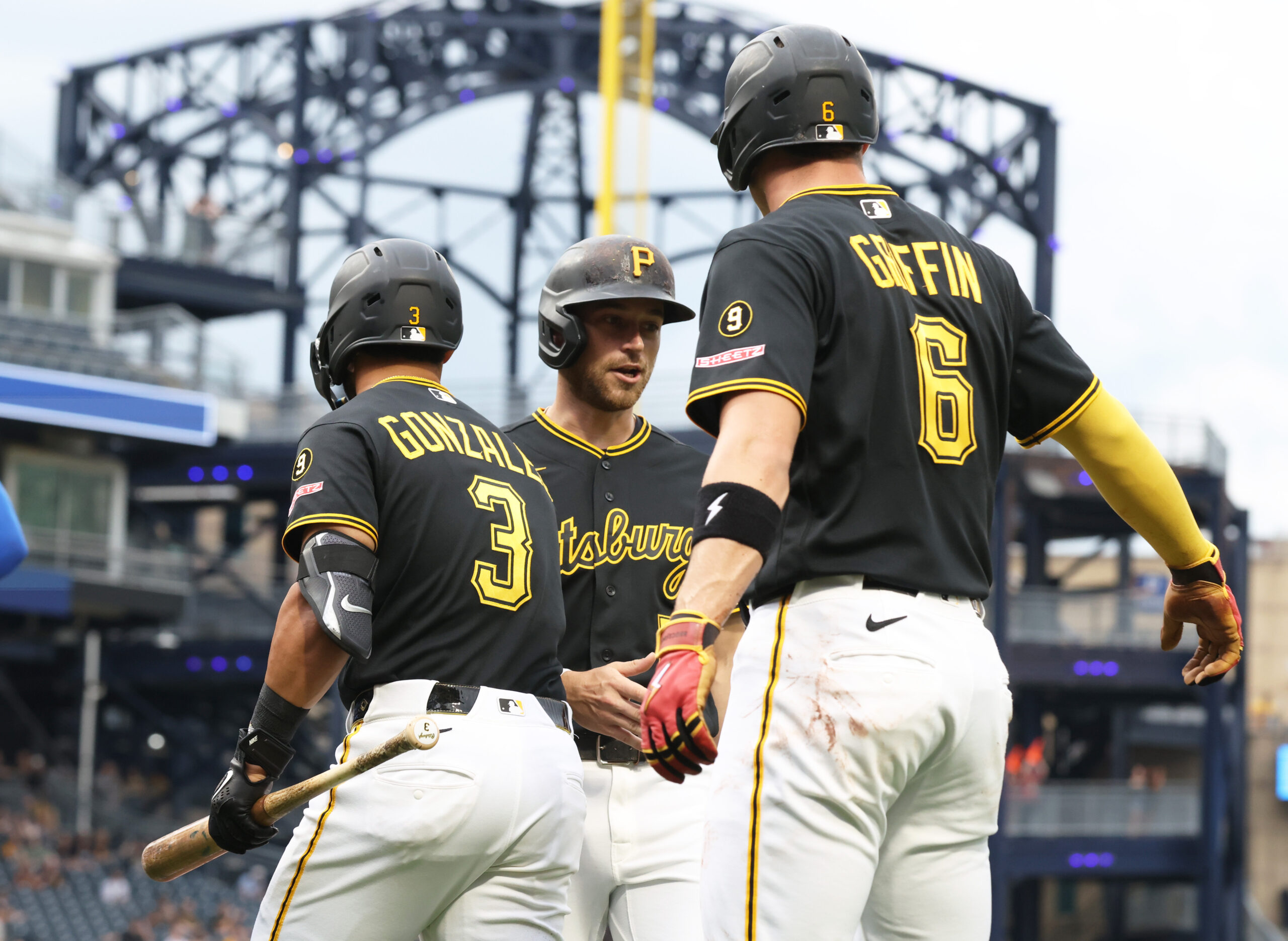 May 26, 2026; Pittsburgh, Pennsylvania, USA;  Pittsburgh Pirates third baseman Nick Gonzales (3) and shortstop Konnor Griffin (6) greet second baseman Brandon Lowe (middle) crossing home plate and scoring a run against the Chicago Cubs during the first inning at PNC Park. Mandatory Credit: Charles LeClaire-Imagn Images