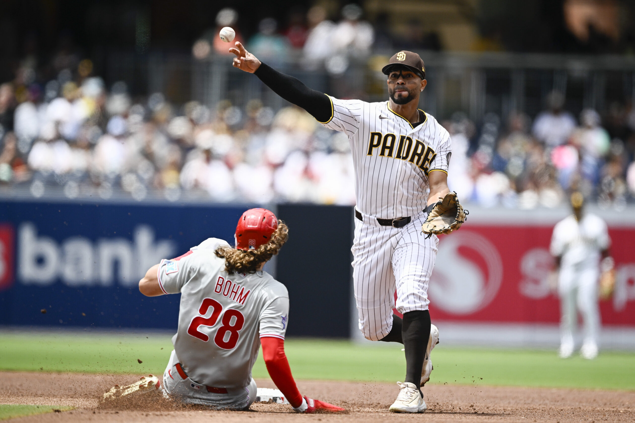 May 27, 2026; San Diego, California, USA; San Diego Padres shortstop Xander Bogaerts (2) throws over Philadelphia Phillies third baseman Alec Bohm (28) as he turns a double play during the second inning at Petco Park. Mandatory Credit: Denis Poroy-Imagn Images