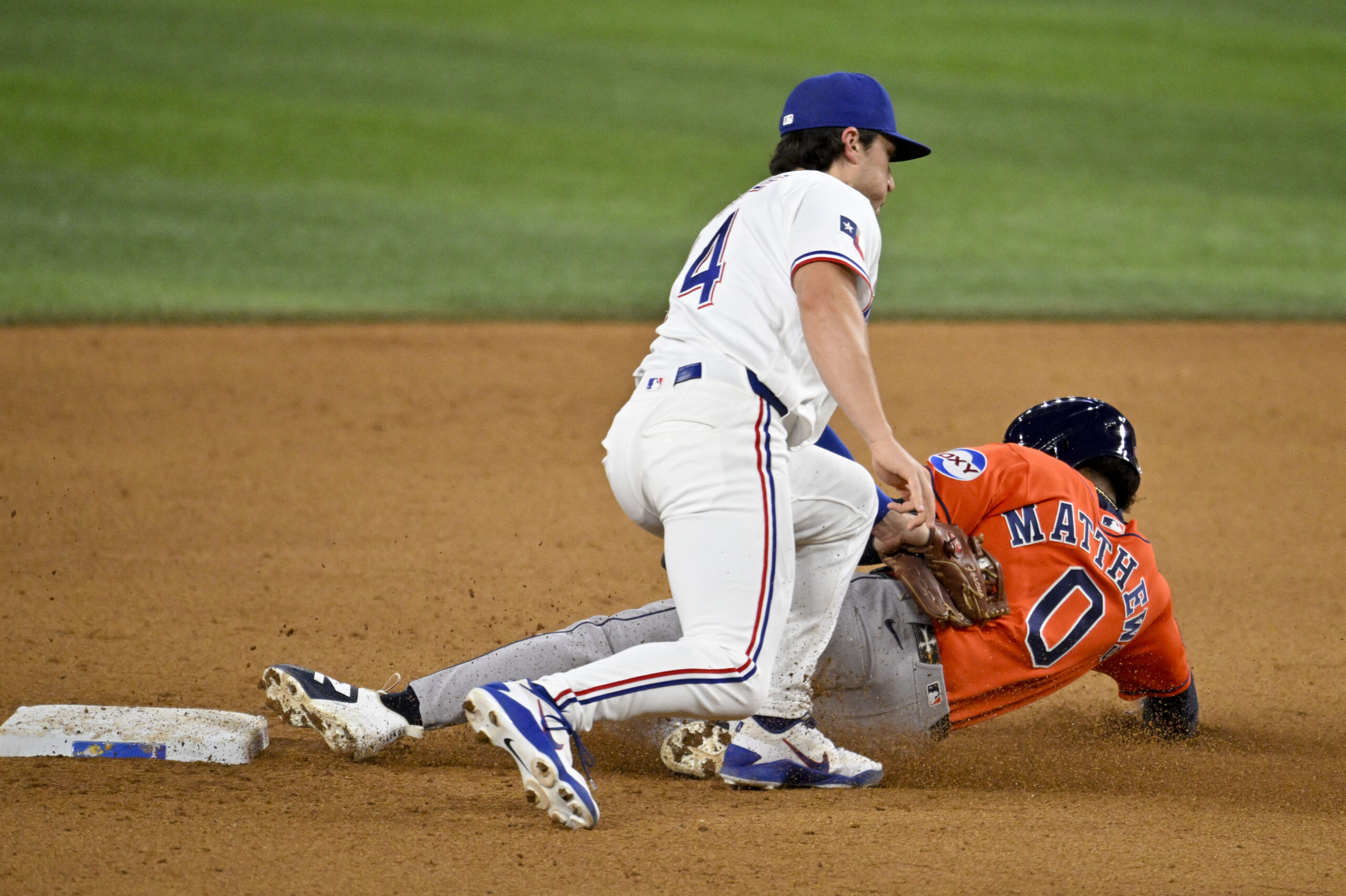 May 27, 2026; Arlington, Texas, USA;  Texas Rangers second baseman Justin Foscue (14) tags out Houston Astros second baseman Brice Matthews (0) during the ninth inning at Globe Life Field. Mandatory Credit: Jerome Miron-Imagn Images