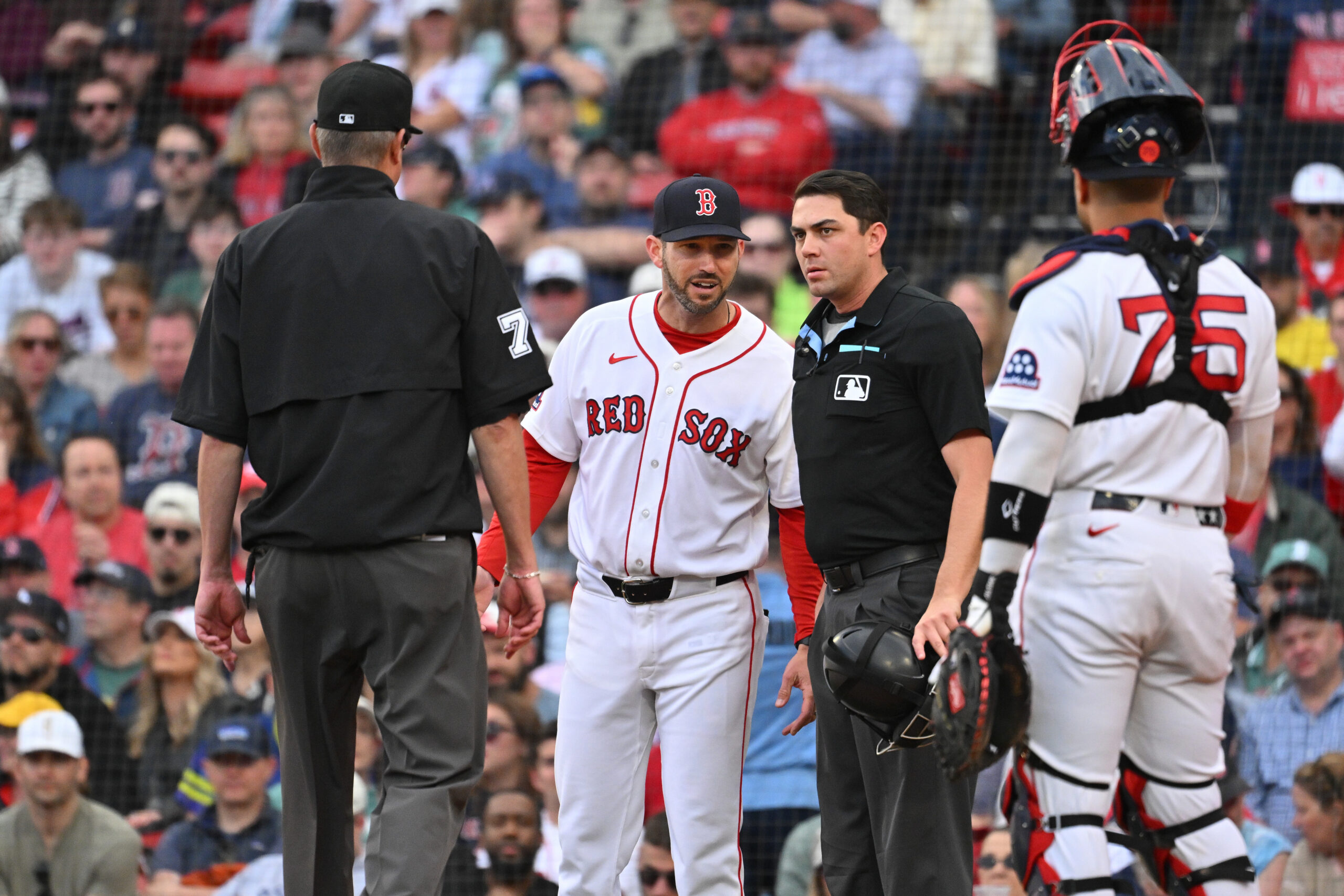 May 28, 2026; Boston, Massachusetts, USA; Boston Red Sox interim manager Chad Tracy (17) questions umpire Willie Traynor (45) (r) and umpire Jordan Baker (71) during the sixth inning against the Atlanta Braves at Fenway Park. Mandatory Credit: Eric Canha-Imagn Images