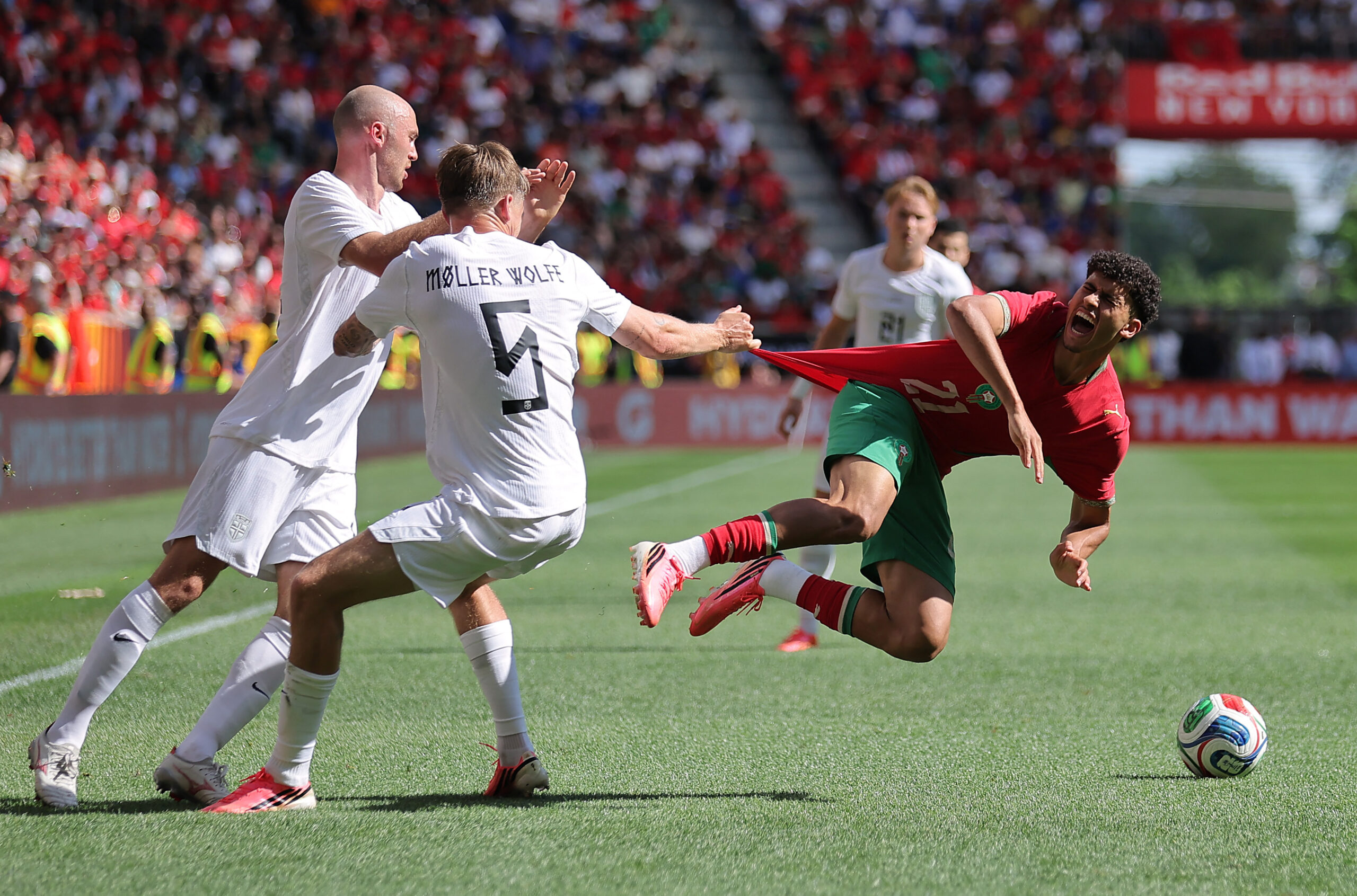 June 7, 2026; Harrison, New Jersey, U.S.; Norway's David Moller Wolfe pulls the jersey of Morocco's Ayoube Amaimouni-Echghouyab as Fredrik Aursnes looks on.  Mandatory Credit: Brad Penner-Imagn Images