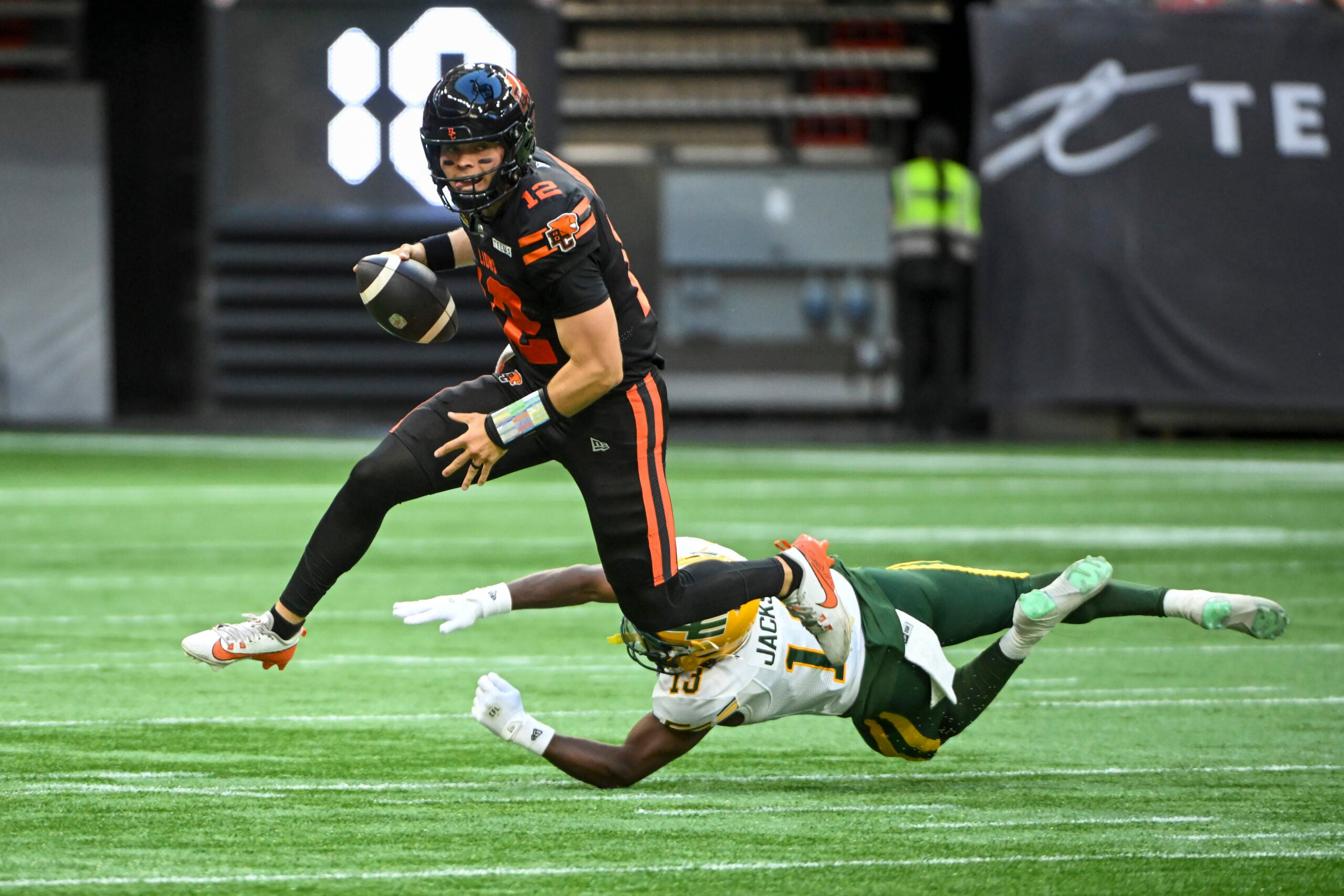 Jun 7, 2025; Vancouver, British Columbia, Canada; BC Lions quarterback Nathan Rourke (12) runs the ball defended by Edmonton Elks defensive back Kordell Jackson (13) at BC Place Stadium. Mandatory Credit: Anne-Marie Sorvin-Imagn Images