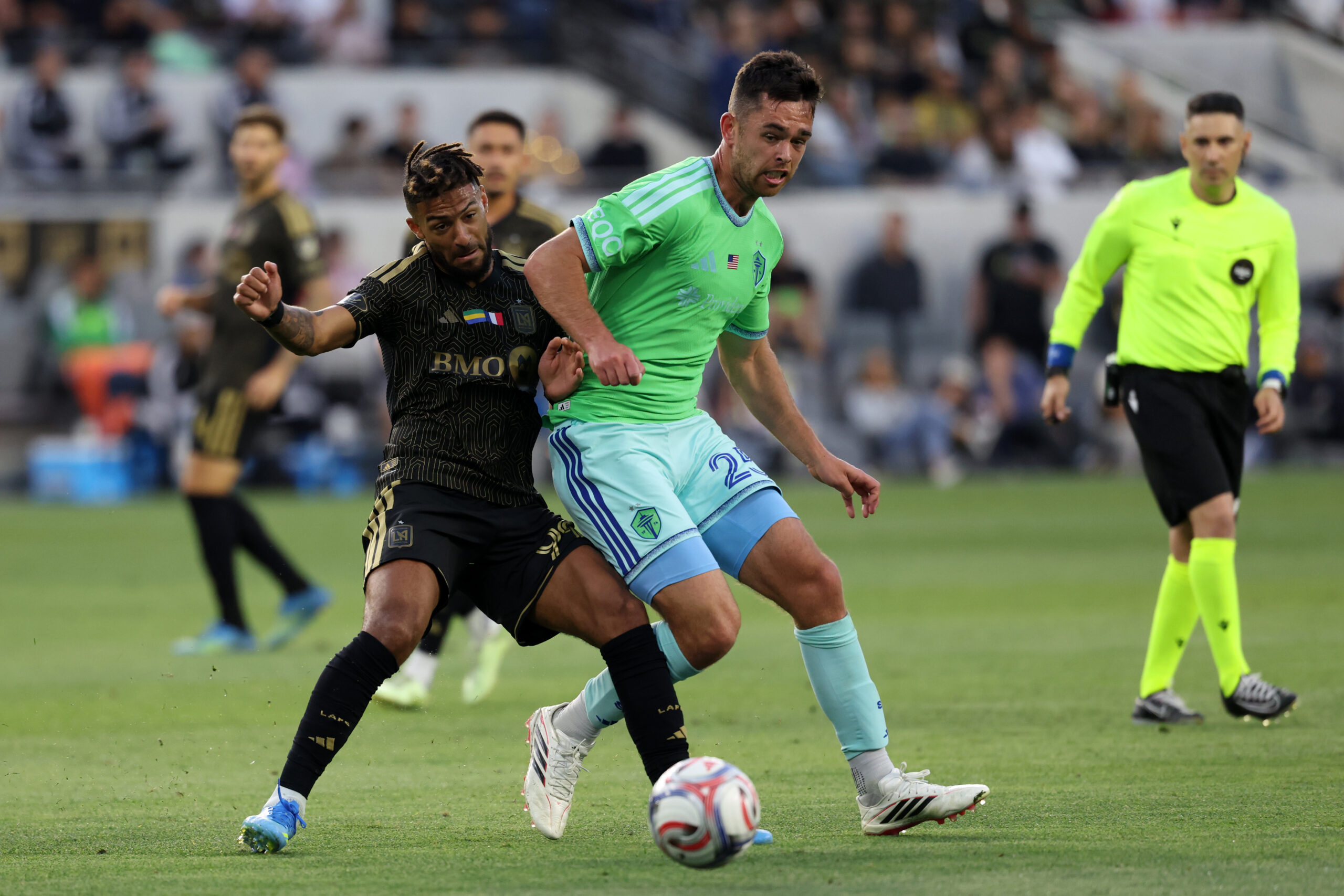 May 24, 2026; Los Angeles, California, USA;  LAFC forward Denis Bouanga (99) and Seattle Sounders FC defender Jackson Ragen (25) fight for the ball during the second half at BMO Stadium. Mandatory Credit: Kiyoshi Mio-Imagn Images
