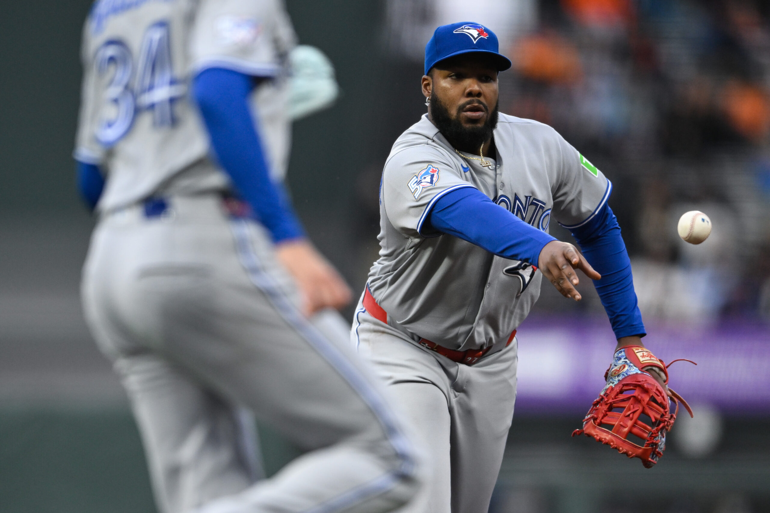 Jul 6, 2026; San Francisco, California, USA; Toronto Blue Jays first baseman Vladimir Guerrero Jr. (27) throws to starting pitcher Kevin Gausman (34) for an out at first base against the San Francisco Giants in the third inning at Oracle Park. Mandatory Credit: Eakin Howard-Imagn Images