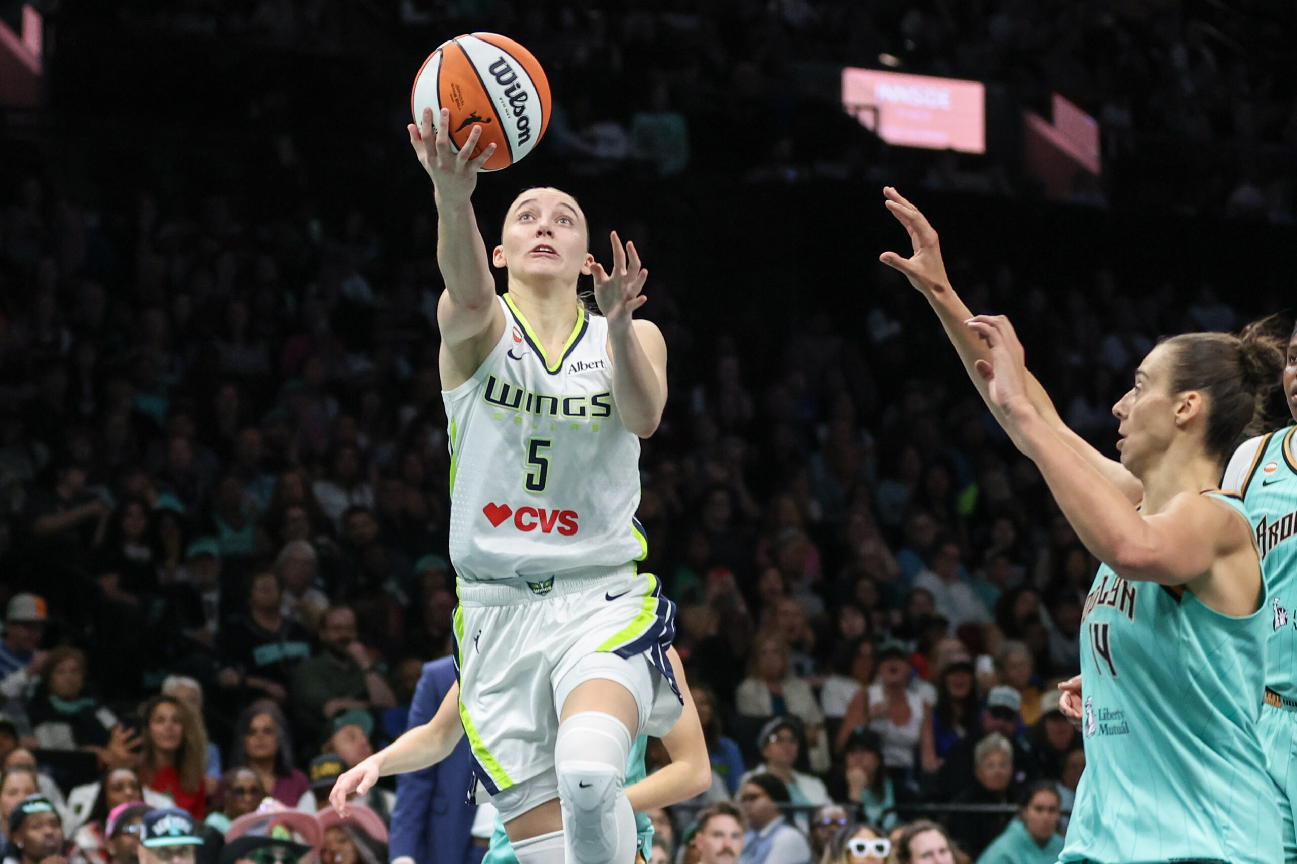 Jul 7, 2026; Brooklyn, New York, USA;  Dallas Wings guard Paige Bueckers (5) drives past New York Liberty center Raquel Carrera (14) in the second quarter at Barclays Center. Mandatory Credit: Wendell Cruz-Imagn Images